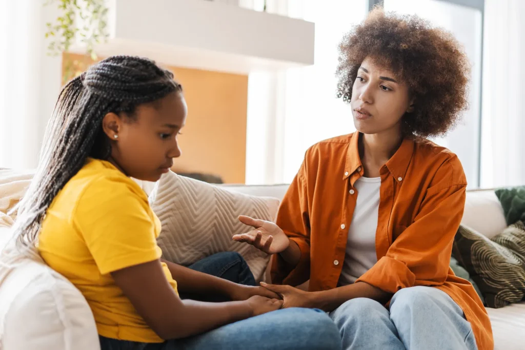 Adult comforting a sad teenager on a couch